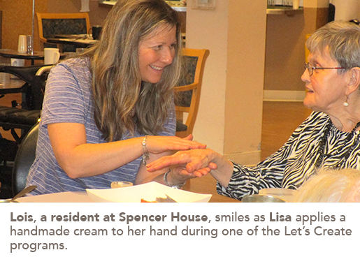 Lois, a resident at Spencer House, smiles as Lisa applies a handmade cream to her hand during one of the Let’s Create programs.