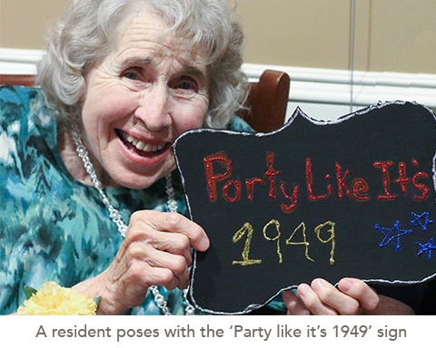 picture of a resident poses with the ‘Party like it’s 1949’ sign